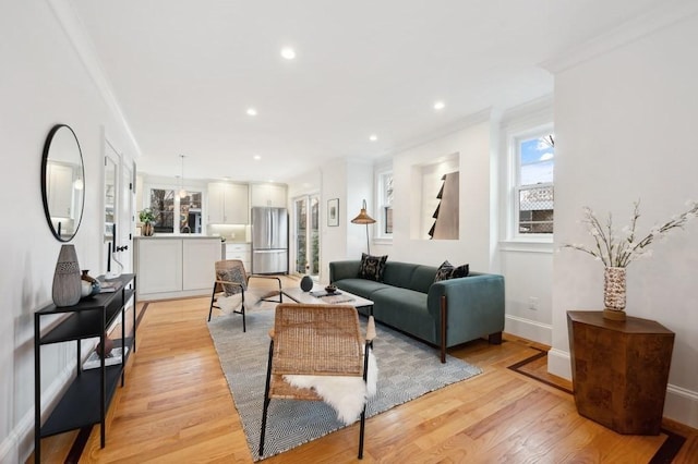 living room with ornamental molding, recessed lighting, baseboards, and light wood finished floors