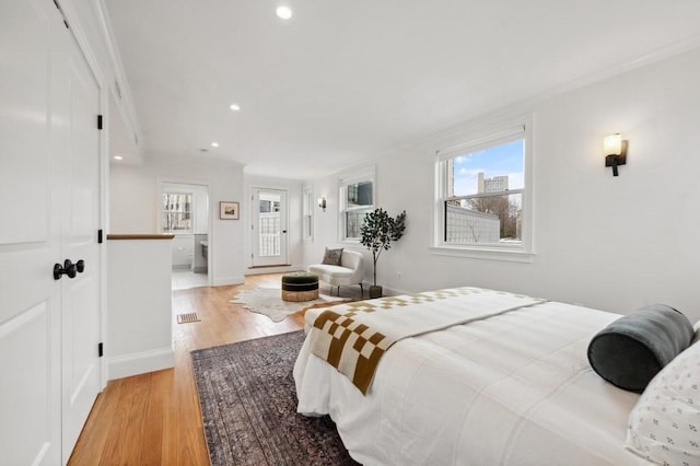 bedroom featuring light wood finished floors, baseboards, ornamental molding, and recessed lighting