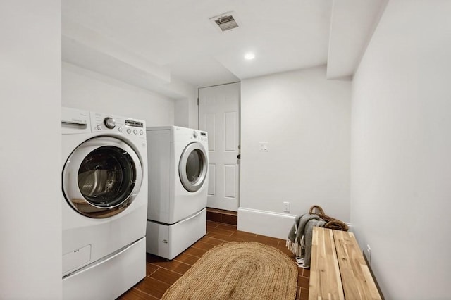 laundry area featuring washer and clothes dryer, visible vents, wood tiled floor, laundry area, and baseboards