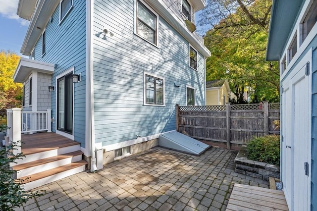 view of property exterior with a patio and fence