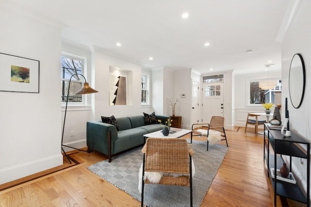 living area with ornamental molding, light wood-type flooring, baseboards, and recessed lighting