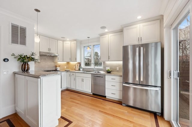 kitchen featuring visible vents, light wood-style flooring, appliances with stainless steel finishes, light stone countertops, and under cabinet range hood