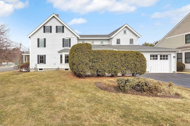 traditional-style home with driveway, an attached garage, and a front lawn