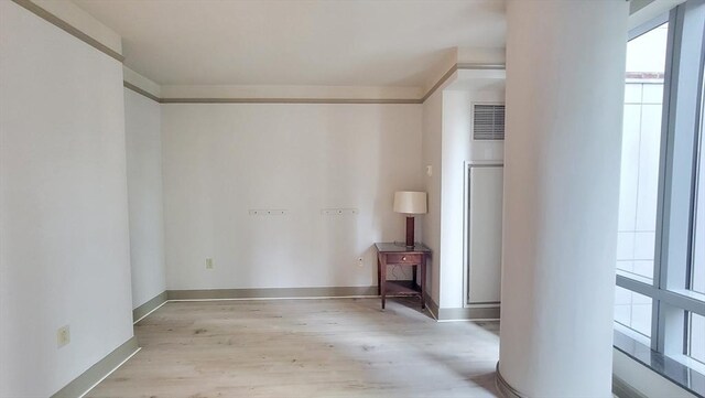 spare room with baseboards and light wood finished floors