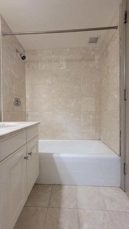 bathroom with shower / bathtub combination, vanity, tile patterned floors, and visible vents