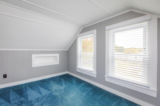 bonus room featuring lofted ceiling, baseboards, and dark carpet