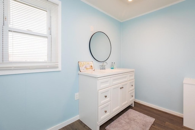 bathroom featuring ornamental molding, vanity, baseboards, and wood finished floors