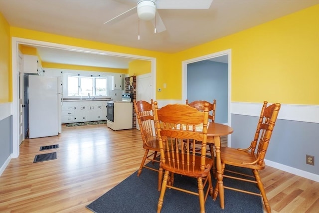 dining room with visible vents, baseboards, light wood-style floors, and ceiling fan