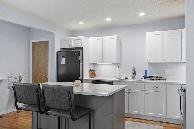 14 Russell Dr Unit 4D, Salem, MA 01970 - kitchen with freestanding refrigerator, a sink, a breakfast bar area, stove, and light wood-style flooring