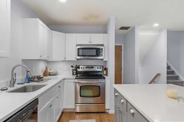 14 Russell Dr Unit 4D, Salem, MA 01970 - kitchen featuring appliances with stainless steel finishes, a sink, white cabinetry, light wood-style floors, and recessed lighting