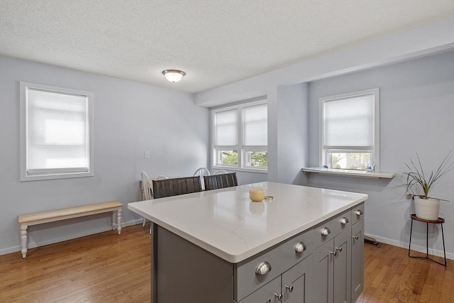 14 Russell Dr Unit 4D, Salem, MA 01970 - kitchen featuring gray cabinets, light wood-type flooring, light countertops, a center island, and baseboards