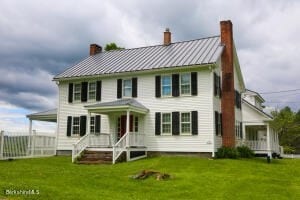 colonial home with a front lawn and covered porch