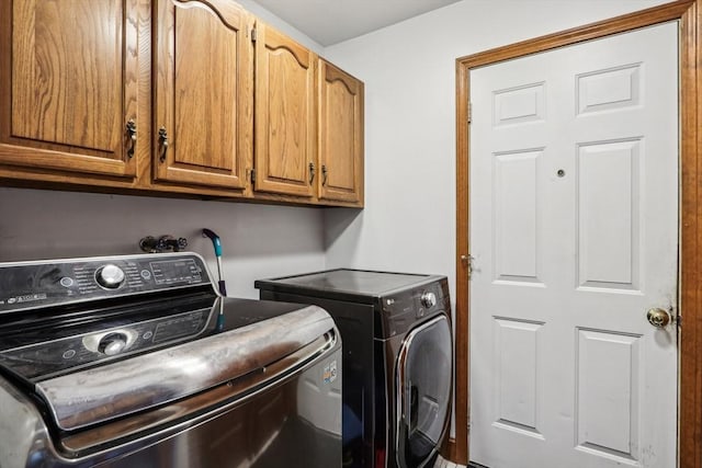 clothes washing area featuring cabinets and washing machine and dryer