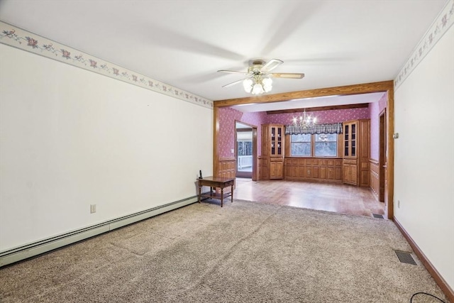 carpeted empty room featuring ceiling fan with notable chandelier and baseboard heating