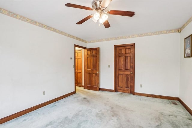 empty room with ceiling fan and light carpet