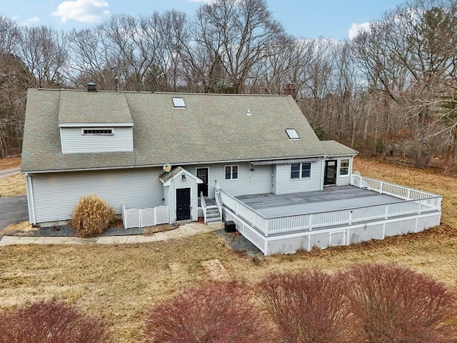 rear view of house with a deck and a lawn