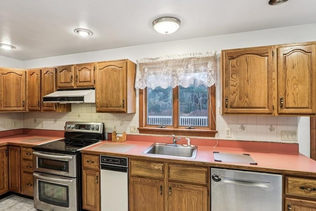 kitchen with light tile patterned floors, stainless steel appliances, tasteful backsplash, and sink