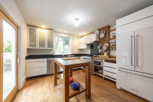 34 Lewis Ave Unit 34, Arlington, MA 02474 - kitchen with built in appliances, white cabinets, light wood-style flooring, open shelves, and glass insert cabinets