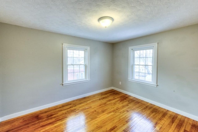 unfurnished room with light hardwood / wood-style floors and a textured ceiling