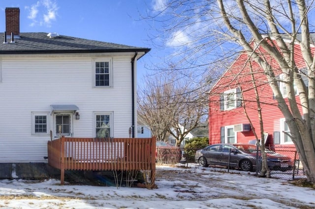 snow covered house featuring a deck