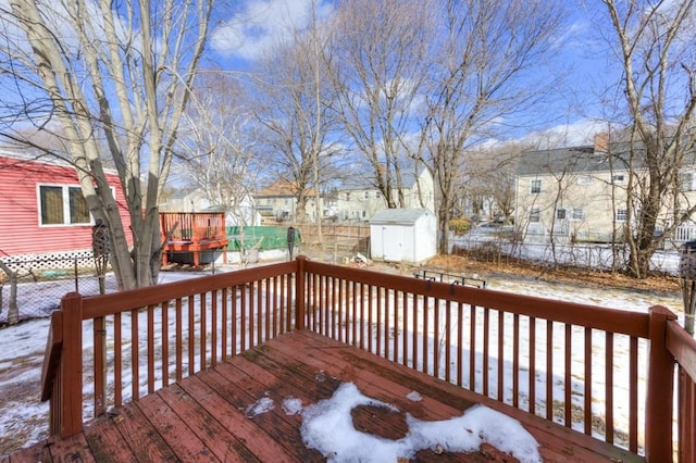 snow covered deck with a shed