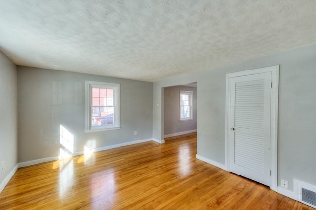 empty room featuring light hardwood / wood-style floors and a textured ceiling