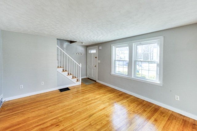 foyer entrance featuring light hardwood / wood-style floors and a textured ceiling