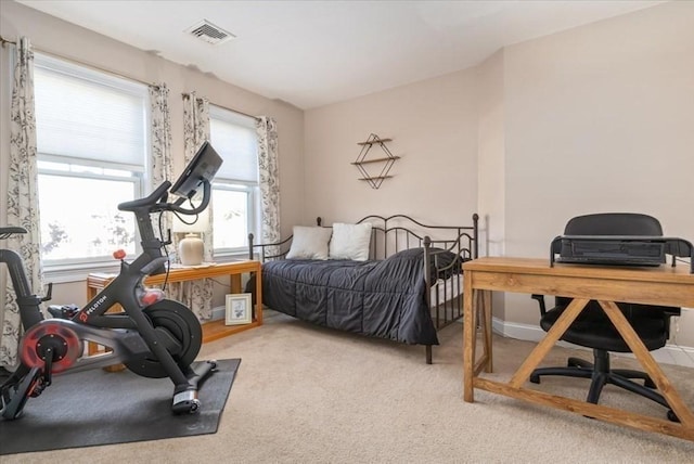 carpeted bedroom with a desk