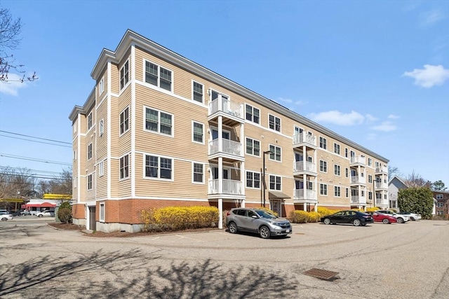 view of apartment building / complex featuring uncovered parking