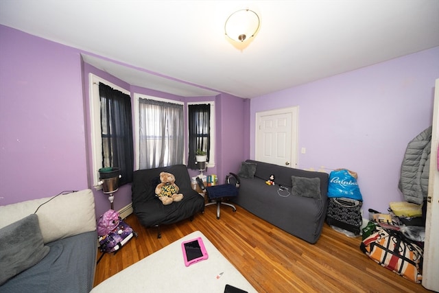 living room with baseboard heating and wood-type flooring