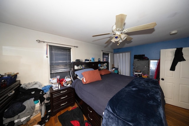 bedroom with dark hardwood / wood-style floors and ceiling fan