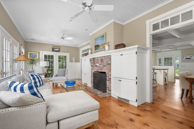 living room featuring ceiling fan, light hardwood / wood-style flooring, crown molding, and a wealth of natural light