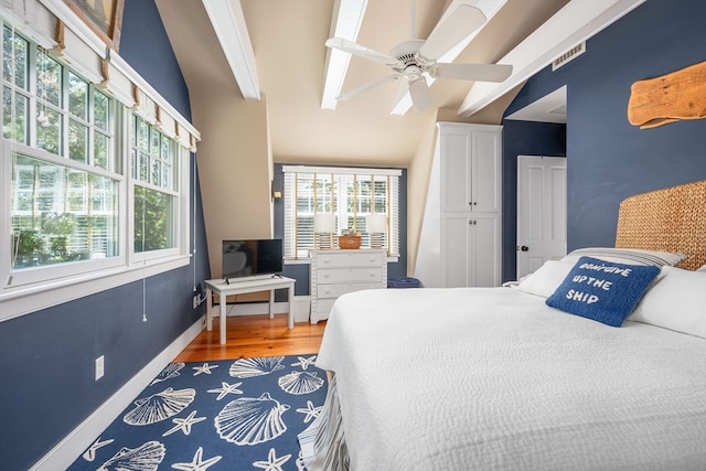 bedroom with lofted ceiling with beams, ceiling fan, a closet, and hardwood / wood-style flooring