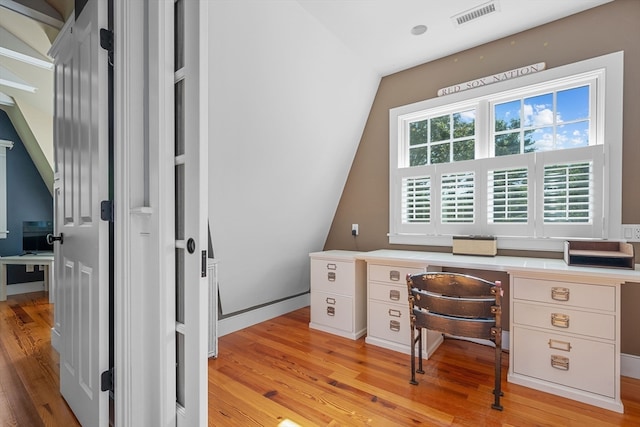 office space featuring light wood-type flooring and vaulted ceiling