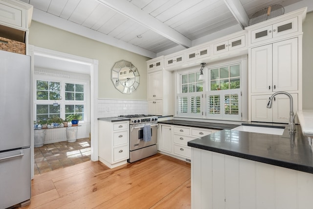 kitchen featuring white cabinets, white refrigerator, and high end stainless steel range oven