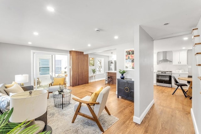 living area with recessed lighting, baseboards, and light wood finished floors