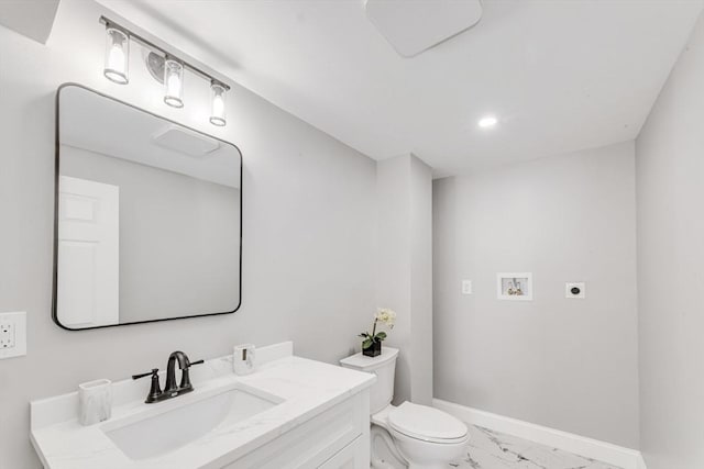 half bathroom with marble finish floor, toilet, vanity, and baseboards