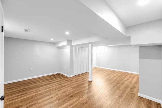 finished basement with recessed lighting, visible vents, baseboards, and light wood-style flooring