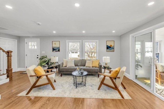 living room with recessed lighting, stairway, plenty of natural light, and light wood finished floors