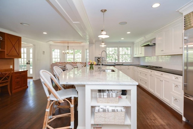 kitchen featuring a sink, ornamental molding, and open shelves