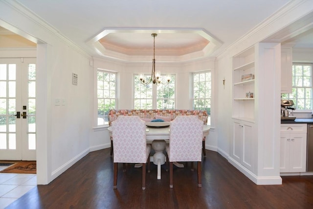 dining area featuring an inviting chandelier, a raised ceiling, a wealth of natural light, and dark wood-style floors