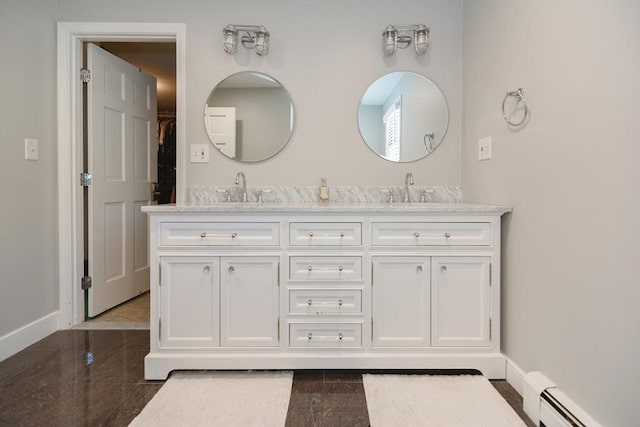 bathroom with a sink, baseboards, a baseboard heating unit, and granite finish floor