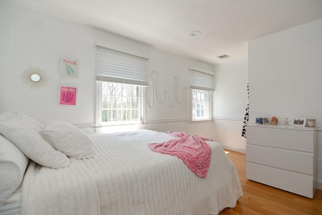 bedroom featuring baseboards, visible vents, and light wood-style flooring