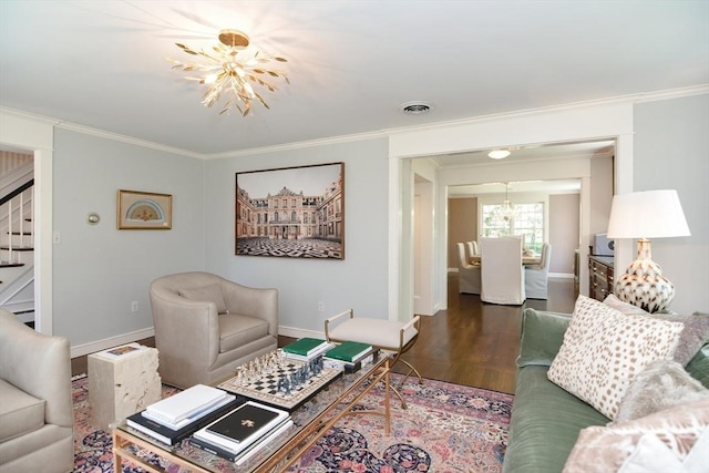 living area with visible vents, ornamental molding, wood finished floors, stairway, and a notable chandelier
