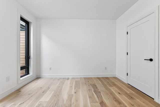 empty room with light wood-style flooring and baseboards