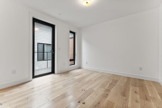 empty room with light wood-style floors and baseboards