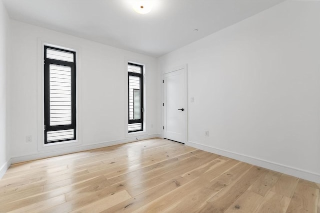 empty room featuring light wood-style floors and baseboards