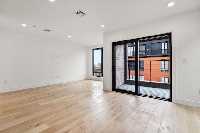 spare room featuring light wood-style floors, baseboards, visible vents, and recessed lighting