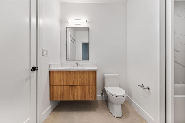 bathroom with tile patterned flooring, baseboards, vanity, and toilet