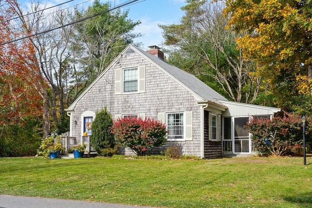 view of side of home with a lawn and a sunroom